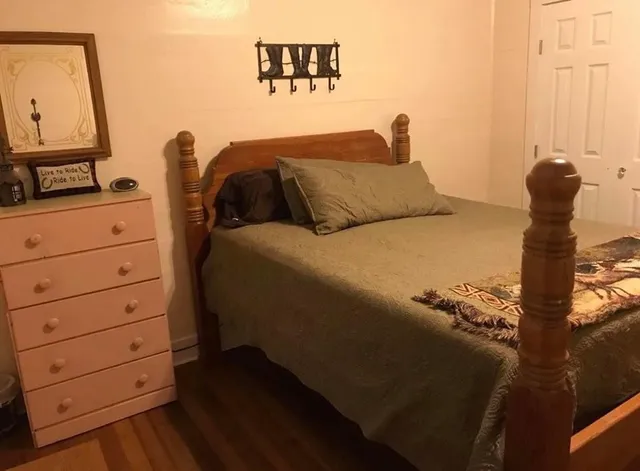 a bedroom with a bed and a dresser in it