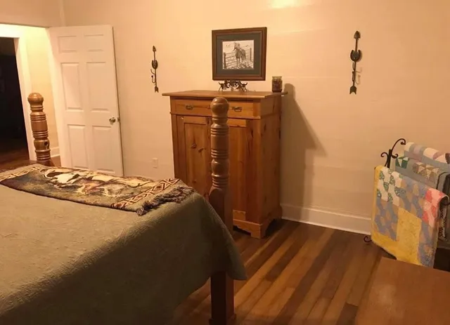 a bedroom with a bed and a flat tv screen on a dresser