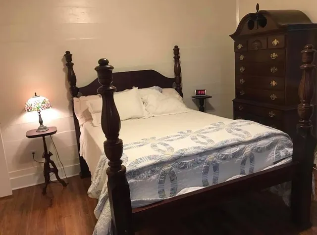 a bed sitting in a bedroom and chandelier