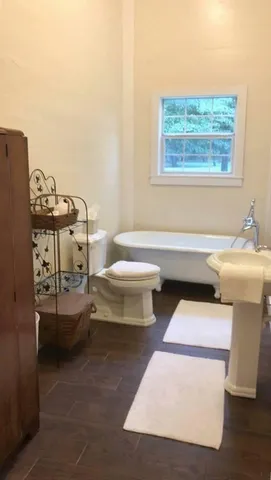 a bathroom with a sink toilet and window