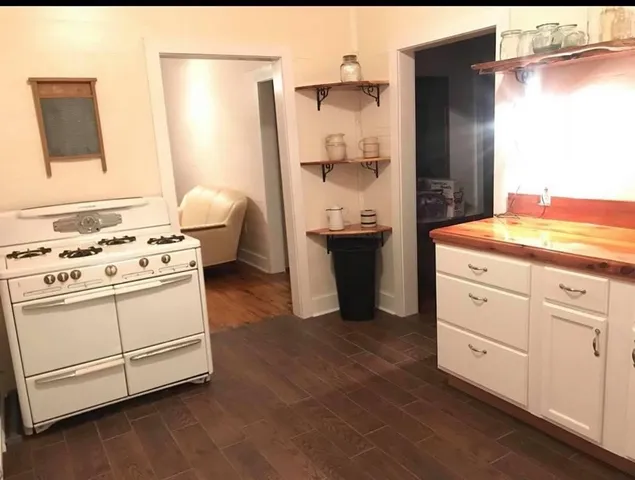 a kitchen with cabinets appliances and wooden floor