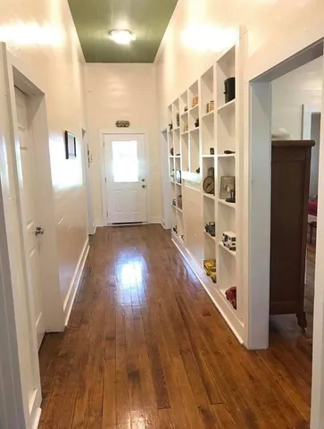 a view of a hallway with wooden floor and stairs