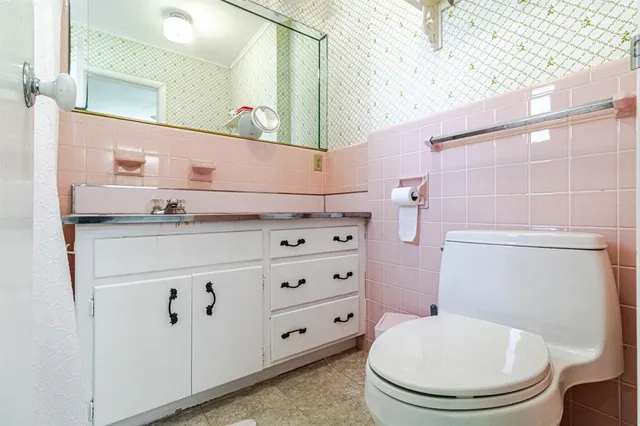 a bathroom with a sink a toilet and a mirror