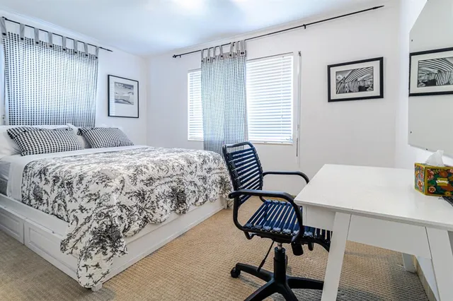 a bedroom with a bed and a lamp on a dresser