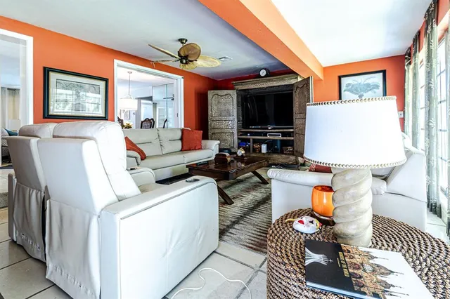 a living room with furniture a flat screen tv and a table