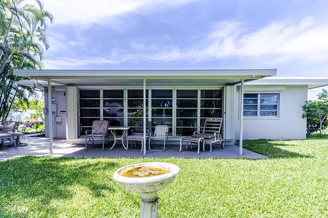 a front view of a house with swimming pool and porch