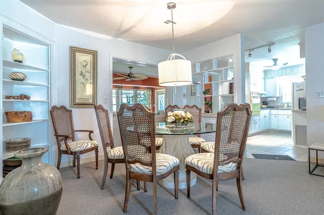 a dining room with furniture a chandelier and wooden floor