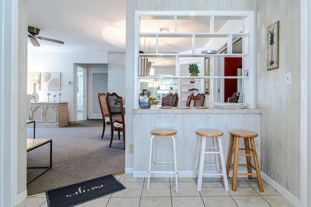 a dining table chair next to a window and kitchen view
