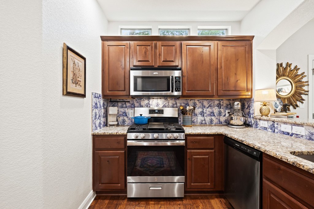 6708 Menchaca Road, Unit 2 Austin, TX 78745 - Photo 8 of 30 Kitchen featuring wood-finish flooring, granite countertops, and a decorative tile backsplash