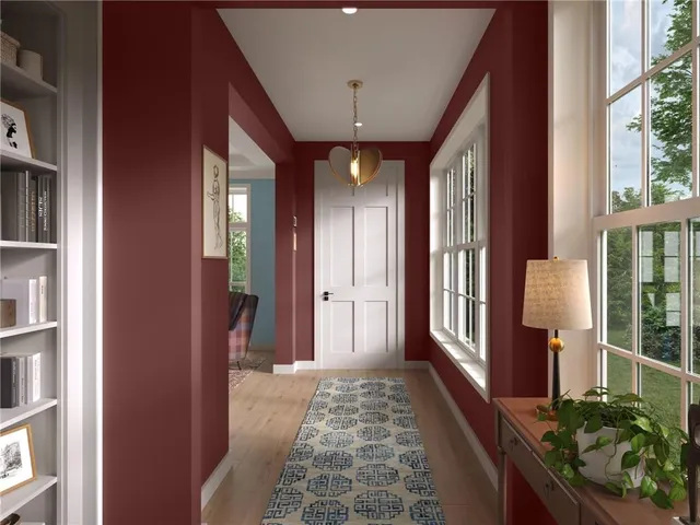 a view of a hallway with wooden floor and windows
