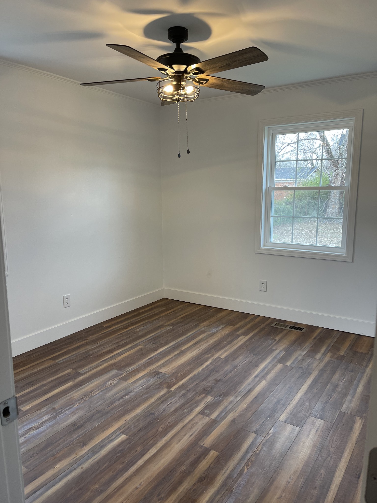 255 Maple Street Savannah, TN 38372 - Photo 14 of 20 en empty room with wooden floor fan and windows