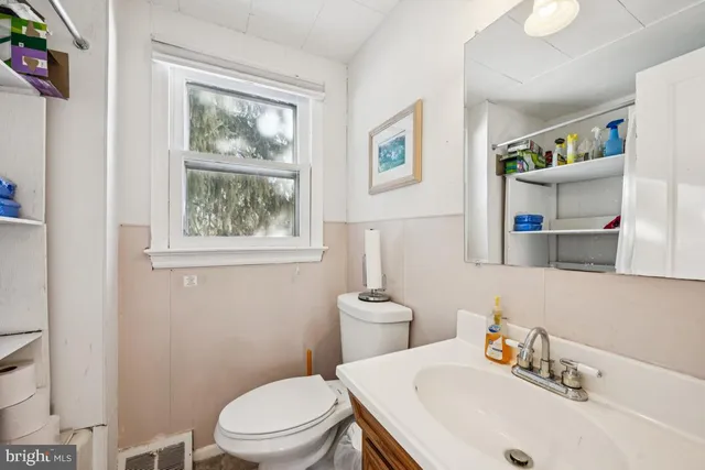 a bathroom with a sink a toilet and a window