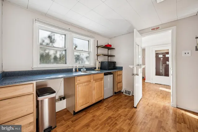 a kitchen with granite countertop a stove a sink and a refrigerator