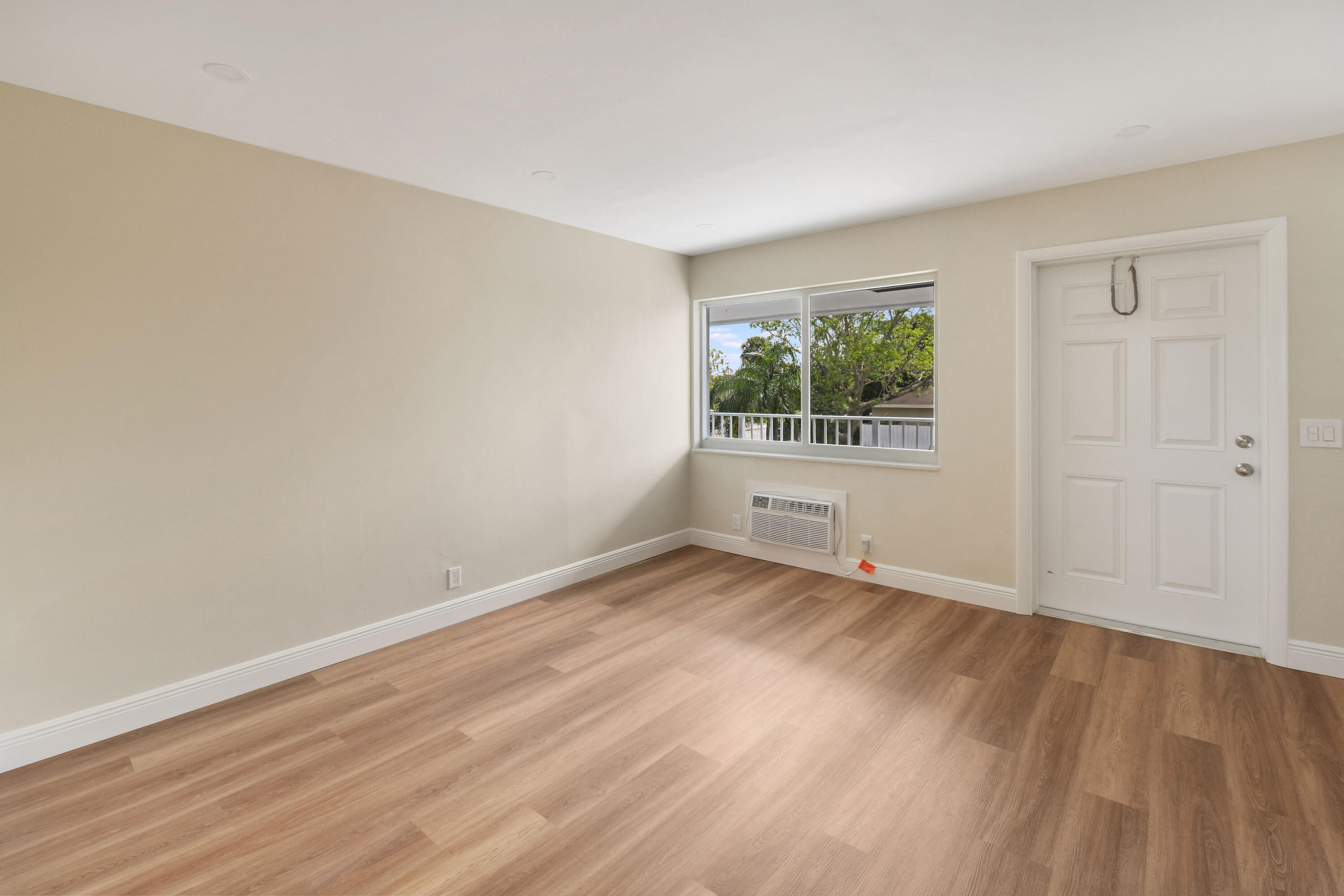 901 North F Street, Unit 8 Lake Worth Beach, FL 33460 - Photo 14 of 15 a view of an empty room with wooden floor and a window