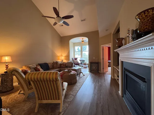 a living room with furniture a fireplace and a ceiling fan