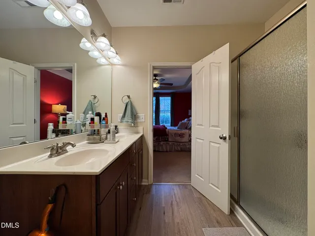 a en suite bathroom with a sink double vanity granite and a mirror