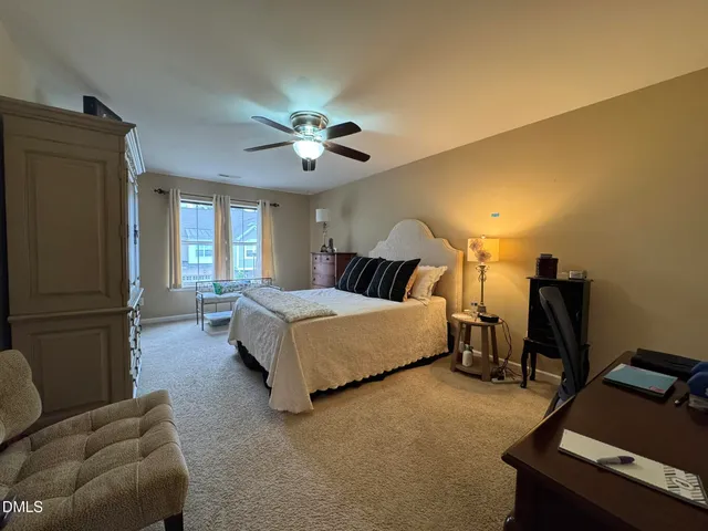 a spacious bedroom with a bed and a chandelier