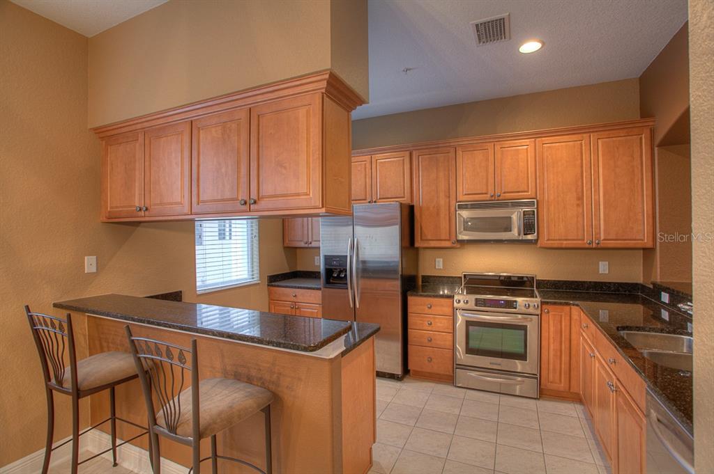 6021 Printery Street, Unit 106 Tampa, FL 33616 - Photo 6 of 23 a kitchen with stainless steel appliances granite countertop a stove a sink dishwasher and a refrigerator