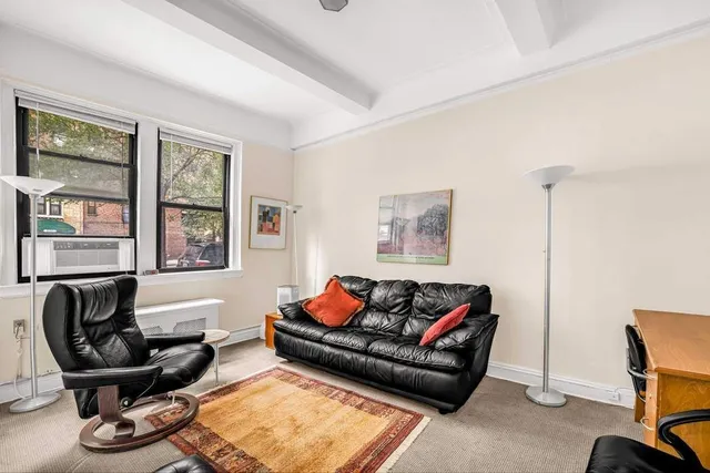 a living room with furniture a couch and paintings on the wall