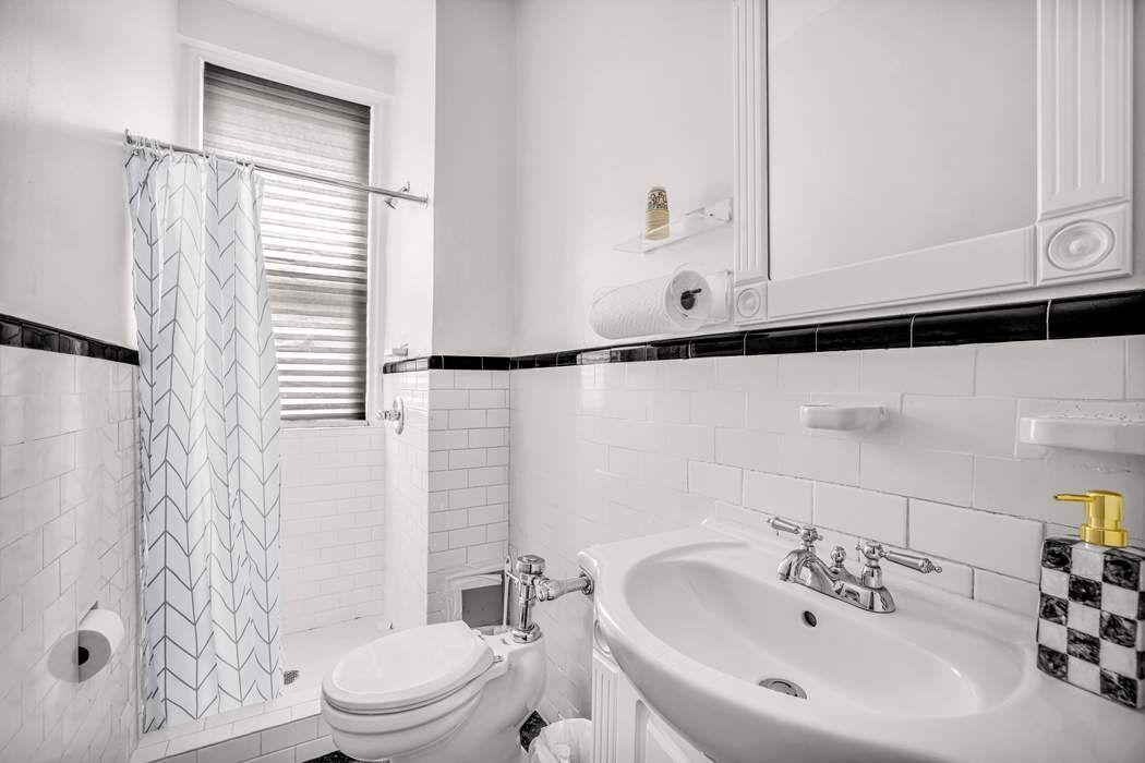 425 East 86th Street, Unit 1B/D Manhattan, NY 10028 - Photo 8 of 10 a bathroom with a sink a toilet and shower curtain