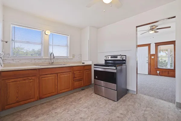a kitchen with granite countertop a stove a sink and a dishwasher