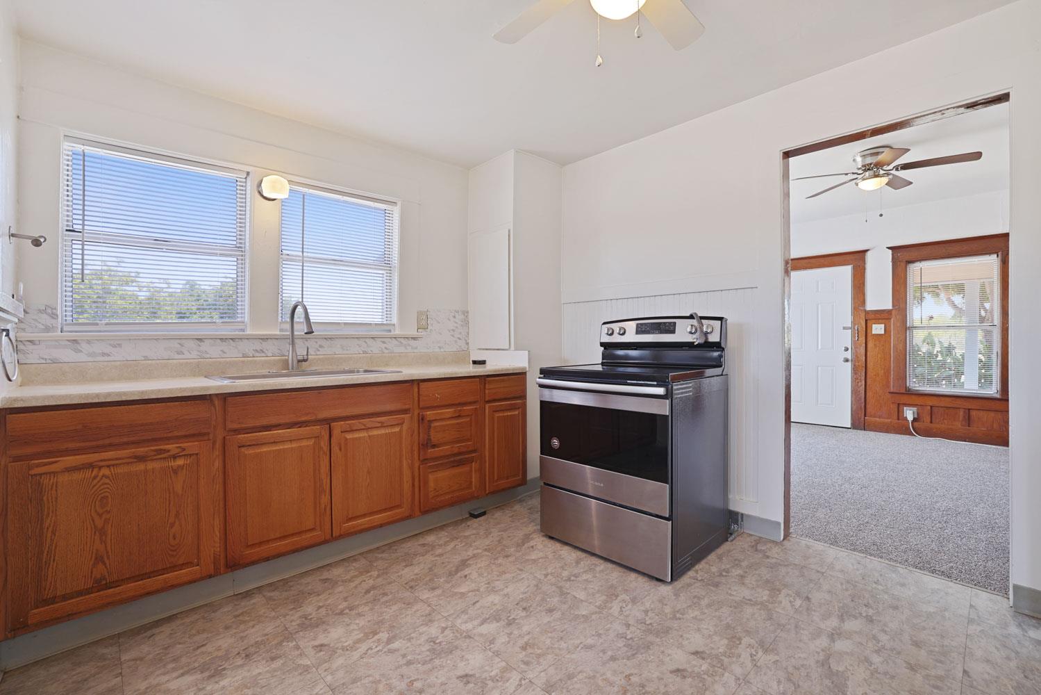 3443 Kansas Avenue Modesto, CA 95358 - Photo 12 of 45 a kitchen with granite countertop a stove a sink and a dishwasher