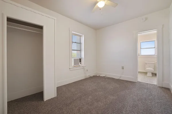 an empty room with chandelier fan