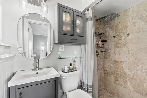 a bathroom with a sink a toilet and shower