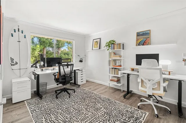 a work room with furniture a rug and a window
