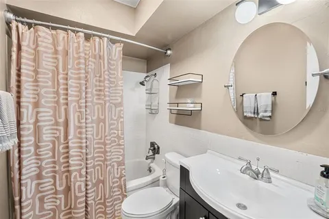 a bathroom with a sink a toilet and shower curtain