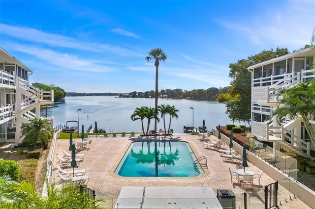 a swimming pool with outdoor seating and lake view