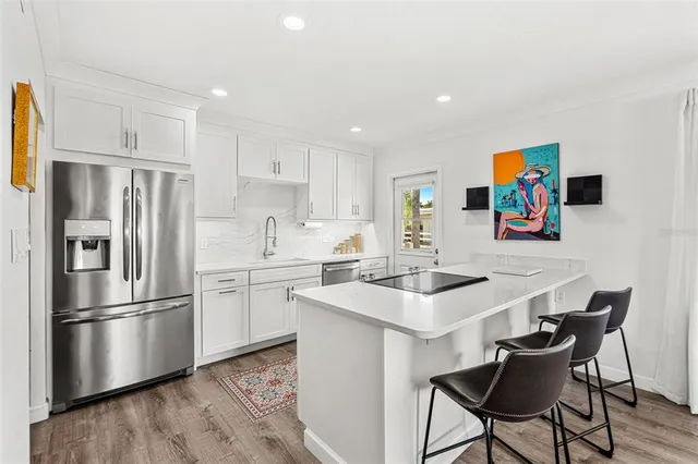 a kitchen with stainless steel appliances a refrigerator a stove a sink and a refrigerator