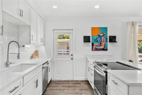a kitchen with stainless steel appliances granite countertop a sink stove and refrigerator