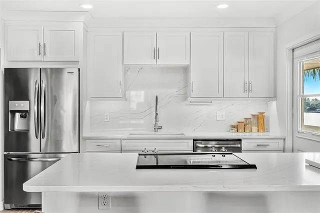 a kitchen with white cabinets and refrigerator