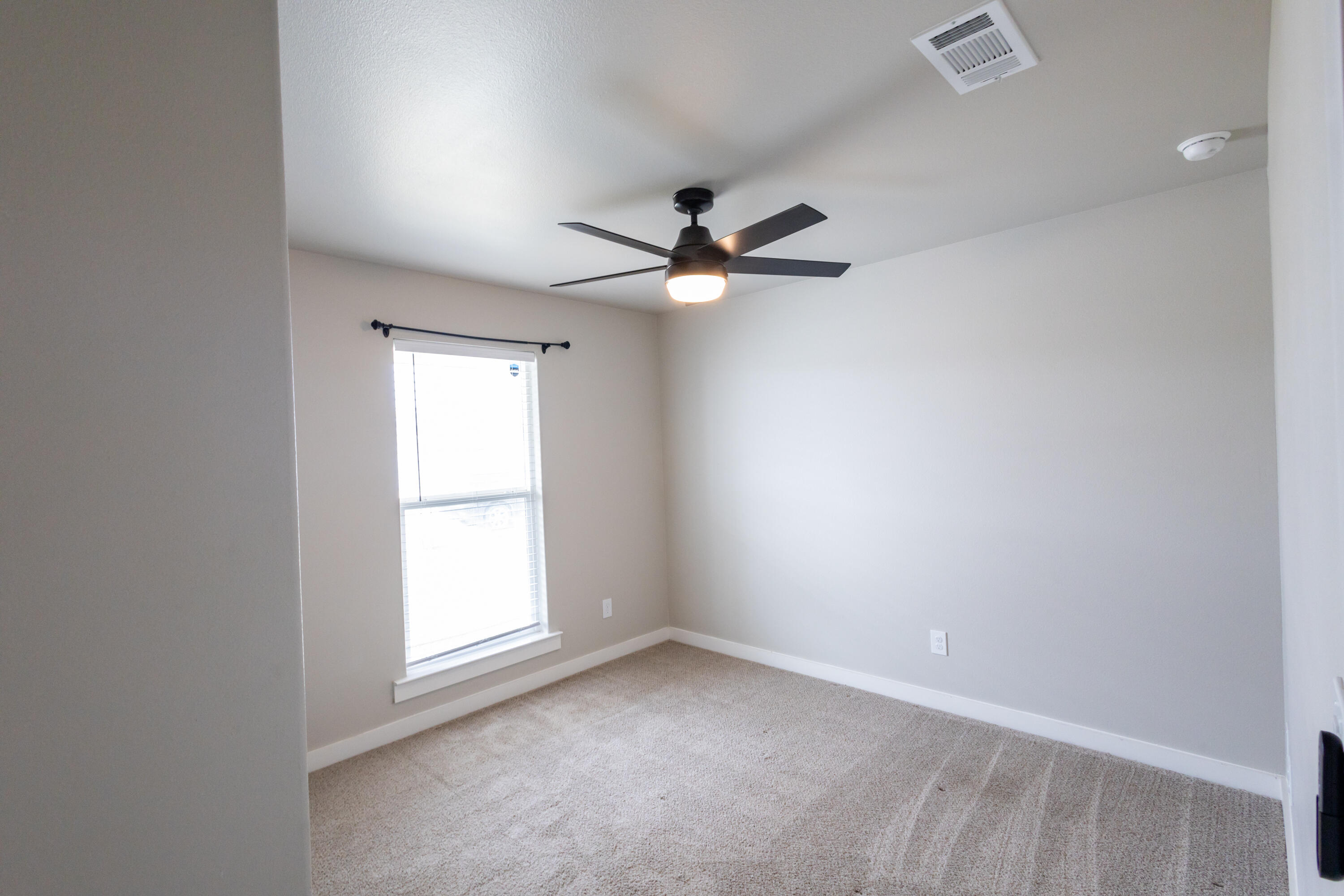 2004 134th Street Lubbock, TX 79423 - Photo 12 of 17 an empty room with a window and a fan