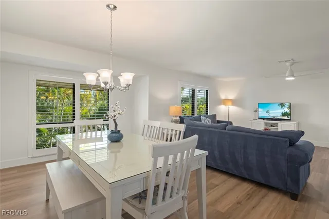 a view of a dining room with furniture a chandelier and wooden floor