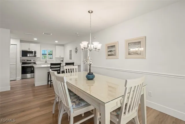a view of a dining room with furniture a chandelier and wooden floor