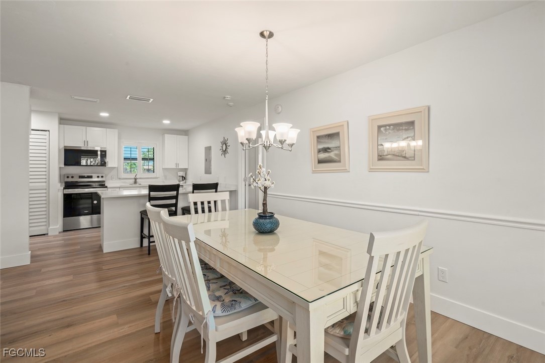 5117 Sea Bell Road, Unit D204 Sanibel, FL 33957 - Photo 14 of 50 a view of a dining room with furniture a chandelier and wooden floor