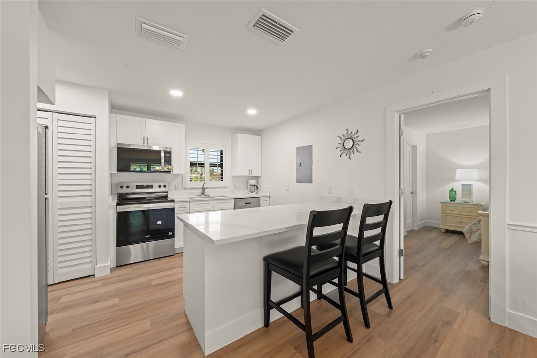 5117 Sea Bell Road, Unit D204 Sanibel, FL 33957 - Photo 16 of 50 a kitchen with kitchen island granite countertop wooden floors a center island and appliances