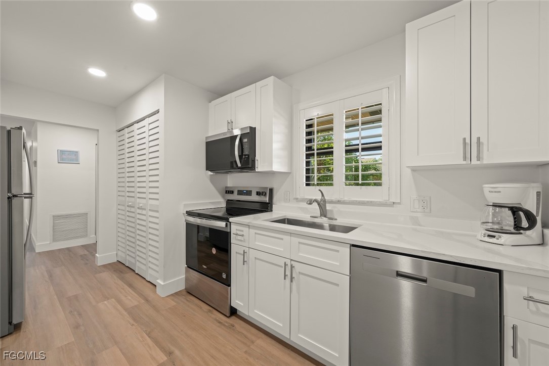 5117 Sea Bell Road, Unit D204 Sanibel, FL 33957 - Photo 17 of 48 a kitchen with a sink cabinets stainless steel appliances and a window