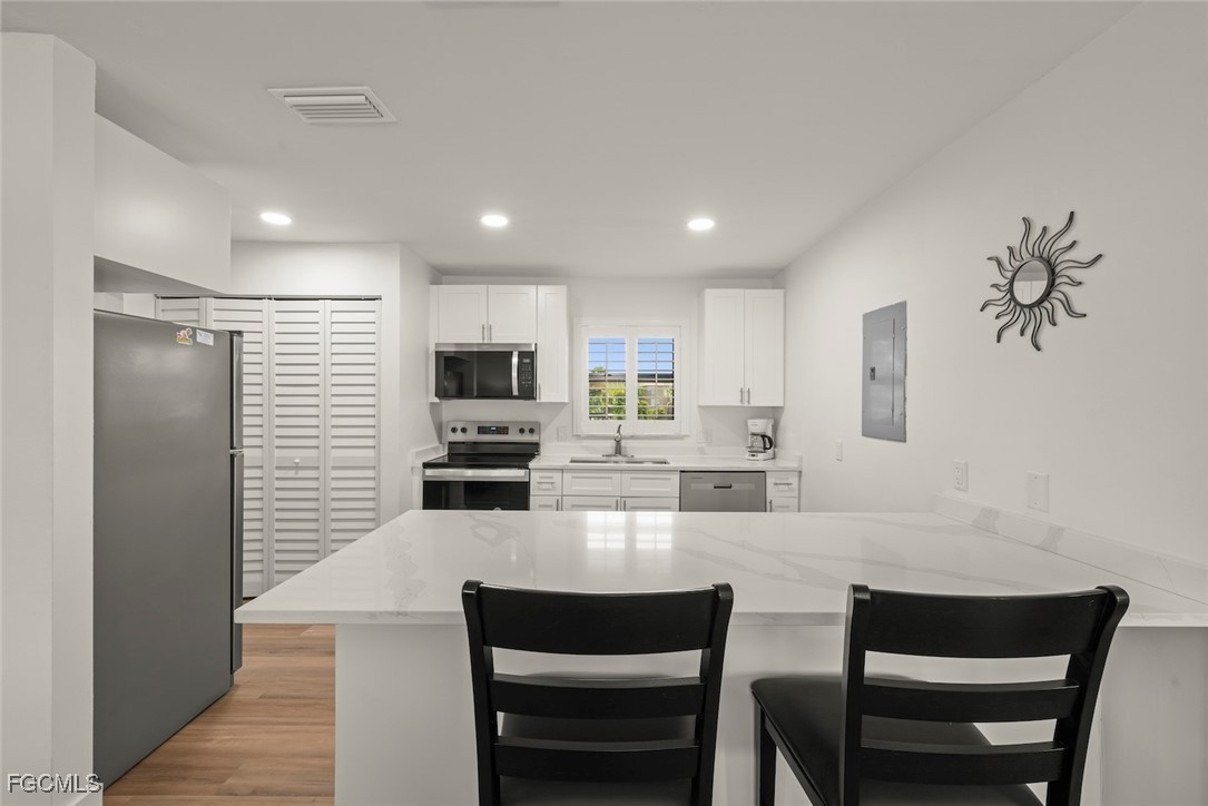 5117 Sea Bell Road, Unit D204 Sanibel, FL 33957 - Photo 22 of 50 a kitchen with stainless steel appliances kitchen island granite countertop a dining table chairs microwave and sink