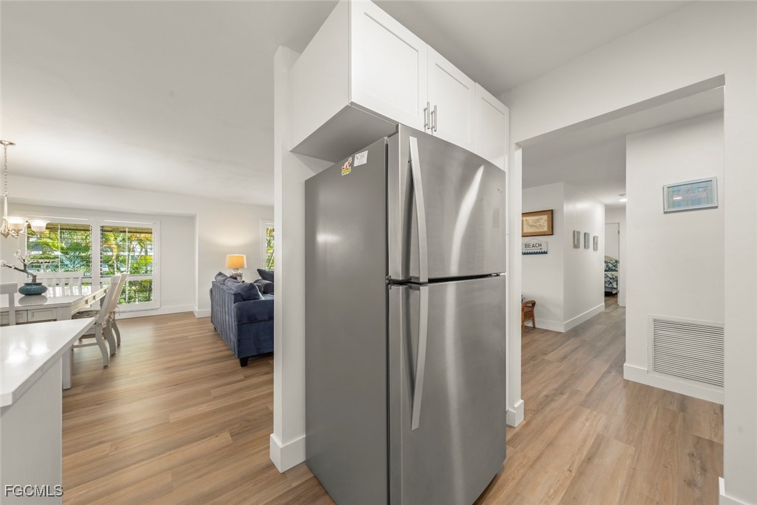 5117 Sea Bell Road, Unit D204 Sanibel, FL 33957 - Photo 25 of 50 a kitchen with stainless steel appliances a refrigerator and wooden floor