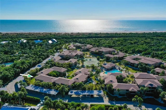 an aerial view of residential houses with outdoor space and trees