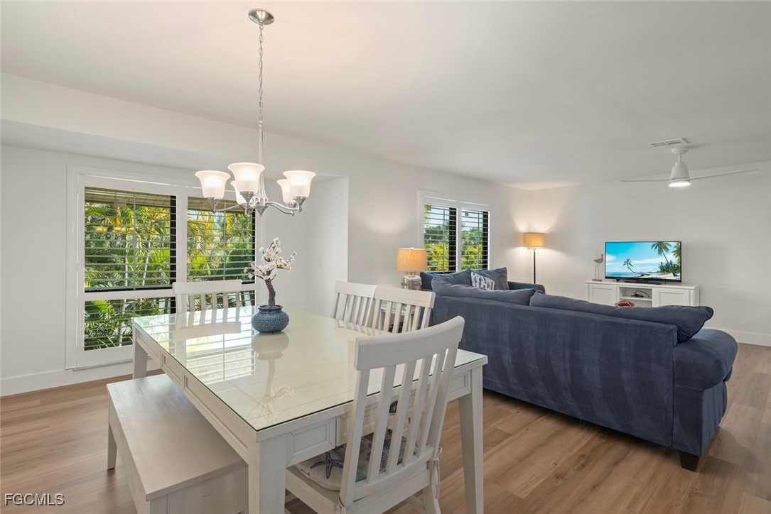 5117 Sea Bell Road, Unit D204 Sanibel, FL 33957 - Photo 3 of 48 a view of a dining room with furniture a chandelier and wooden floor