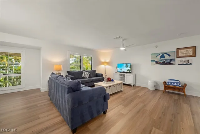 a living room with furniture and a wooden floor
