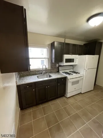 a kitchen with a sink a stove a microwave and cabinets