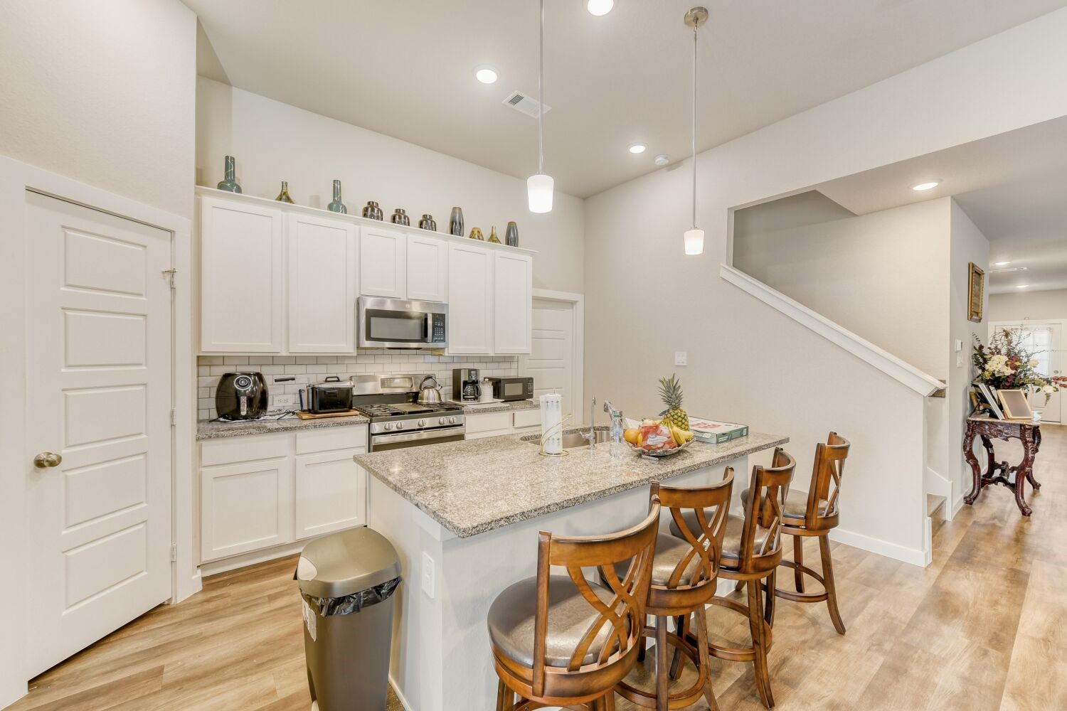 437 Ridge Palm Road Magnolia, TX 77354 - Photo 11 of 31 a kitchen with granite countertop a table chairs stove and white cabinets