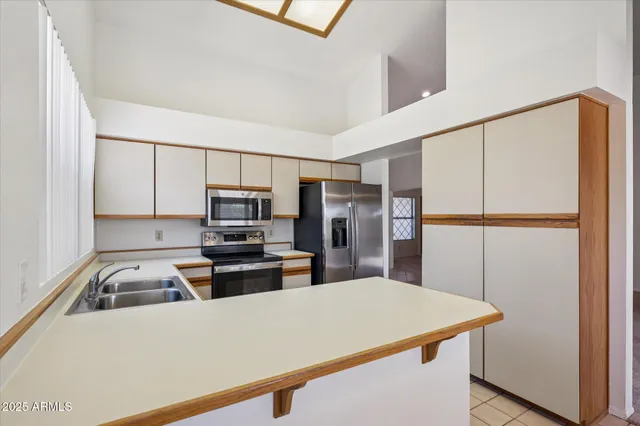 a kitchen with kitchen island a sink stainless steel appliances and counter space