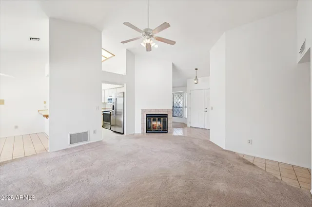 an empty room with fireplace and fan