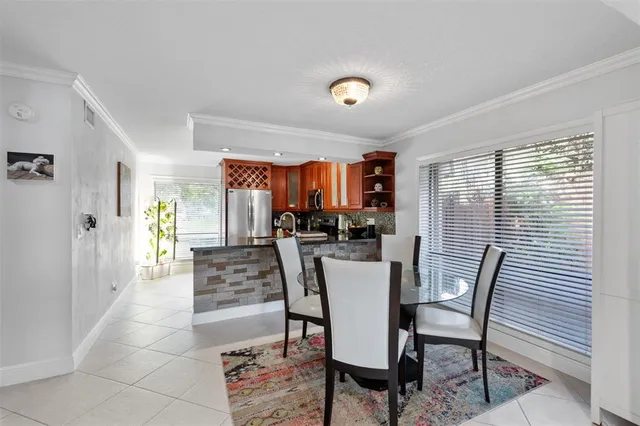 a kitchen with stainless steel appliances granite countertop a stove a refrigerator a kitchen island a table and chairs